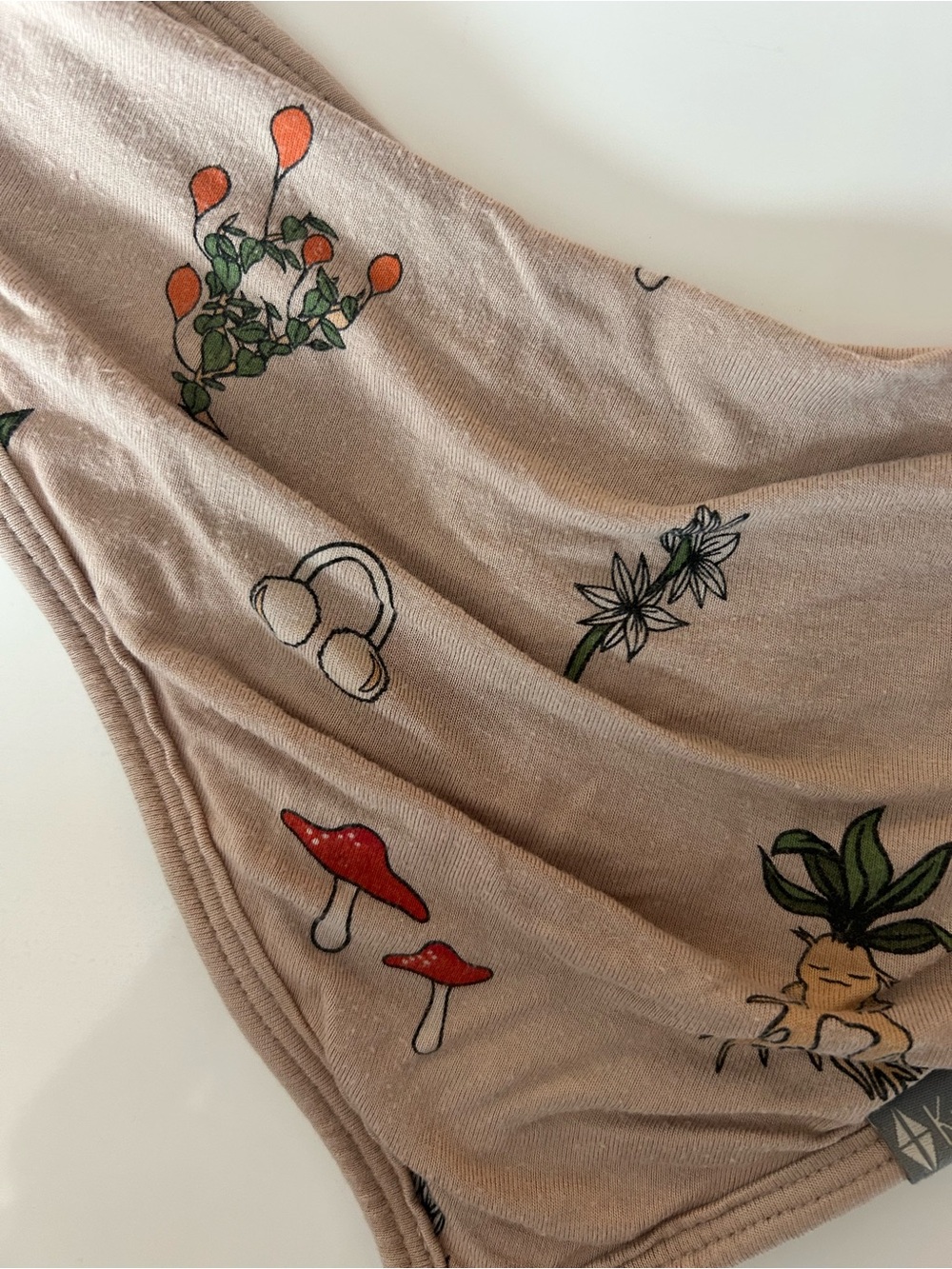 Kyte BABY Beige Bib with Red Mushroom and Green Plant Prints
